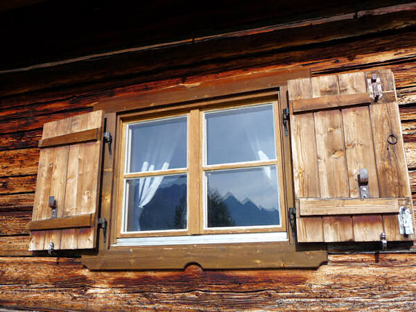 Die Allgäuer Alpen spiegeln sich im Hüttenfenster.